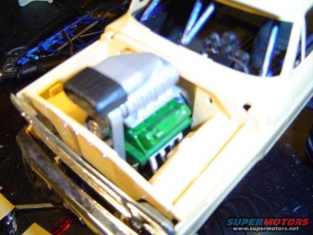 Model car engine bay with green engine and silver supercharger
