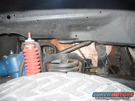 Front suspension with red shock absorber and blue steering component
