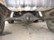 1985 Ford Bronco - Underside view shows the rear axle, fuel tank, and suspension components of a vehicle.