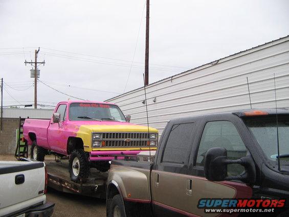 Pink and yellow 1981 Chevrolet C/K Pickup, 3/4 front view, on a trailer