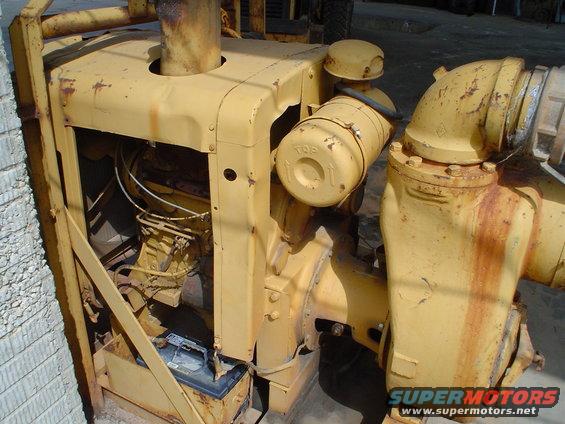yellow industrial engine with pipes and air filter, battery visible below