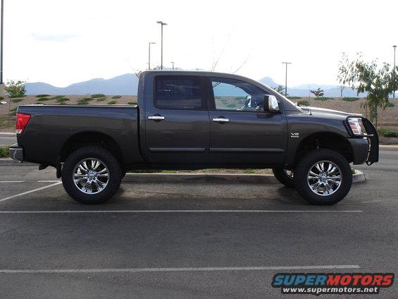 Dark gray lifted pickup truck, side view. V8 badge visible