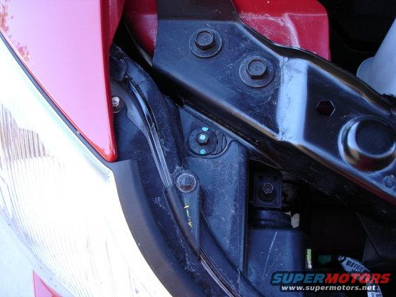 Red vehicle fender and black headlight bracket with bolts and wiring
