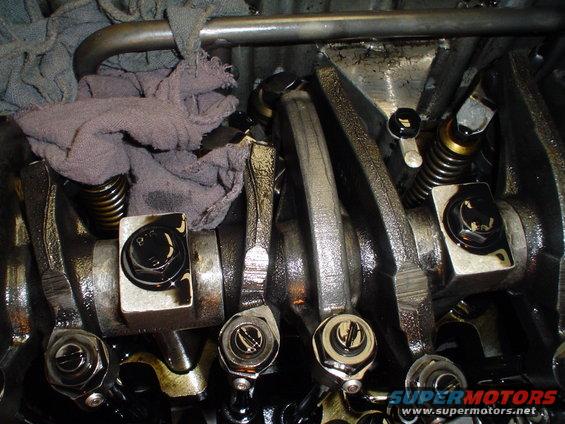 Close-up of engine valve train with oil and rags