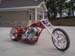 1979 Ford Bronco - A custom chopper motorcycle is parked on a paved surface in front of a building.