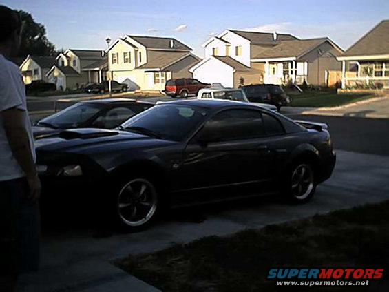 Dark 2004 Ford Mustang coupe, 3/4 front view, parked in driveway