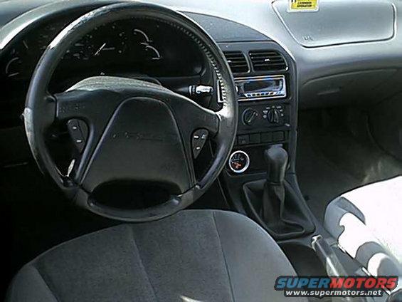 1996 Ford Probe interior with gray seats, black steering wheel, and dashboard. A "SUPERMOTORS.NET" watermark is visible