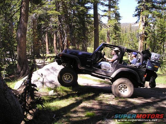 Black Jeep Wrangler TJ navigating rocky terrain