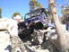 1989 Ford Bronco - A blue Jeep Wrangler is shown navigating a challenging rocky trail during an off-road excursion.