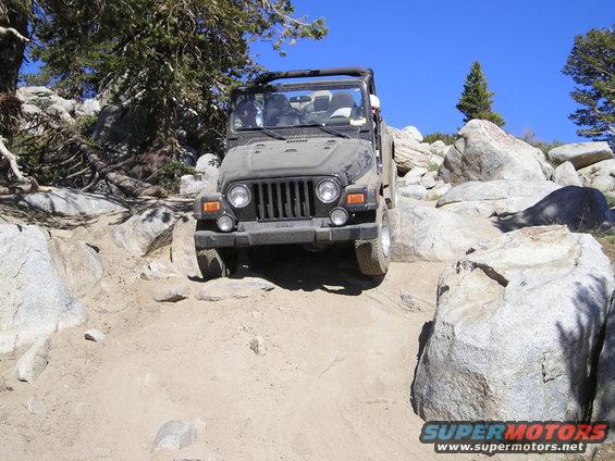 Jeep Wrangler TJ driving over rocks on a trail