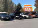 1999 Ford Crown Victoria - Several Ford Crown Victoria police cars are lined up with their hoods open in front of a XXX Root Beer establishment.