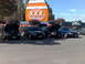 1999 Ford Crown Victoria - Several Ford Crown Victorias are gathered in a parking lot with a large XXX Root Beer advertisement in the background.
