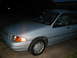 1995 Ford Escort - This 1995 Ford Escort sedan is seen from the front quarter angle at night.