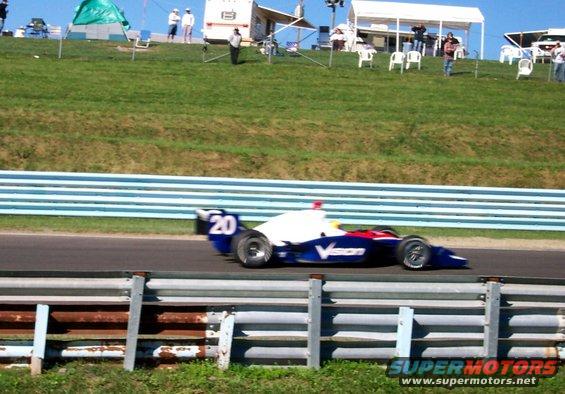 Race car with number 20 and 'Vision' logo on track