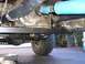 1979 Chevrolet C/K Pickup - Close-up view of the undercarriage of a vehicle, focusing on the drivetrain components and a tire.