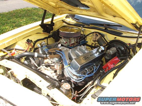 Close-up of a Ford Racing V8 engine with a chrome air cleaner and blue spark plug wires