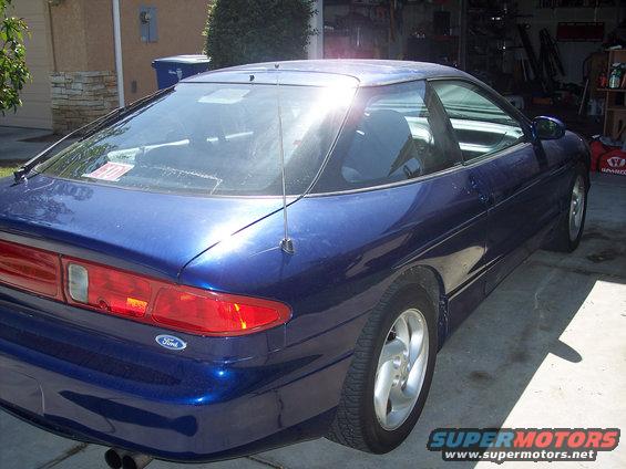 Blue 1995 Ford Probe coupe, rear 3/4 view. Shows taillight, antenna, and alloy wheel