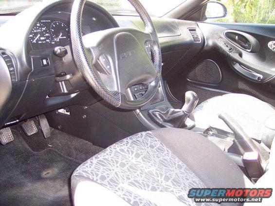 Interior of a 1995 Ford Probe showing the dashboard, steering wheel, gear shifter, and seats