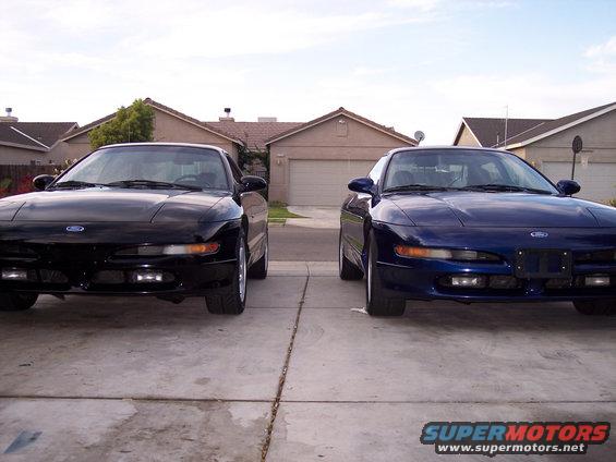 Two Ford Probes, one black and one blue, parked front-end out in a driveway