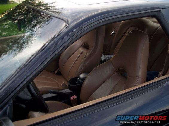 Interior view of a car showing brown leather bucket seats and part of the dashboard