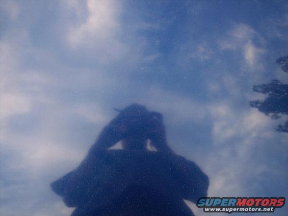 Reflection of photographer in blue car hood