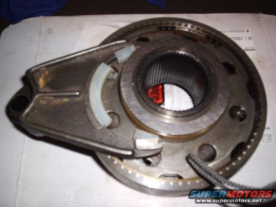 Close-up of a metal transfer case component with splines and a red tag inside