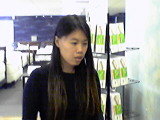 Woman in black shirt looking to the right, with displays in the background