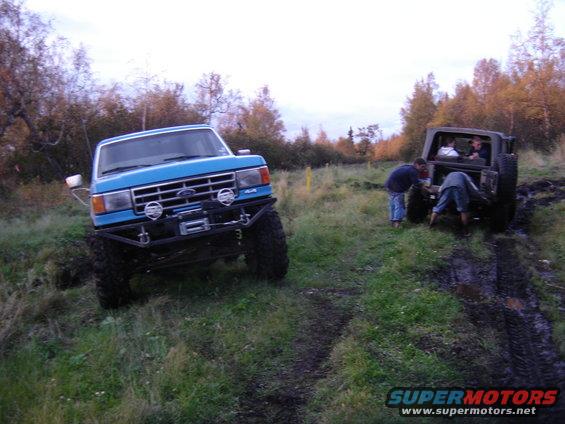 Blue Ford truck with custom bumper and winch, 3q front view