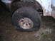 1994 Ford Bronco - A vehicle is stuck with a flat tire in a muddy area.