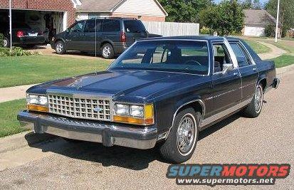 Dark blue sedan parked on a residential street, front quarter view. Chrome grille and bumper visible