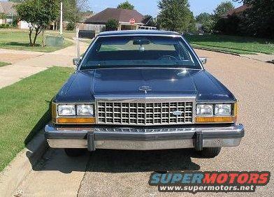 Front view of a dark blue 1985 Ford Crown Victoria LTD parked on a residential street