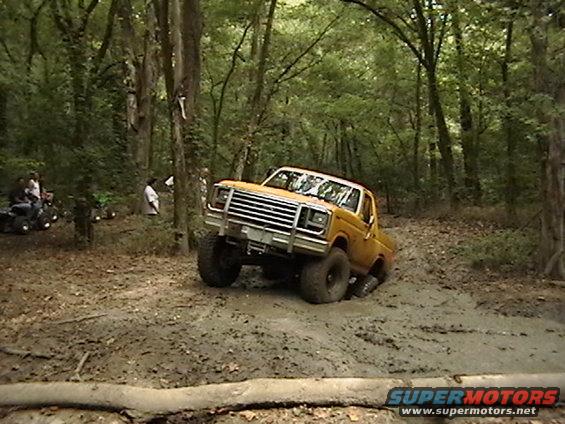 Yellow off-road truck stuck in mud, 1980s grille visible