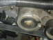 1986 Ford Mustang - A close-up view of a vehicle's engine belt tensioner assembly, showing part markings.