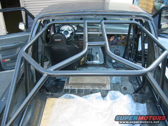 Interior of a 1992 Ford Bronco with a custom rollcage, racing seat, and exposed wiring