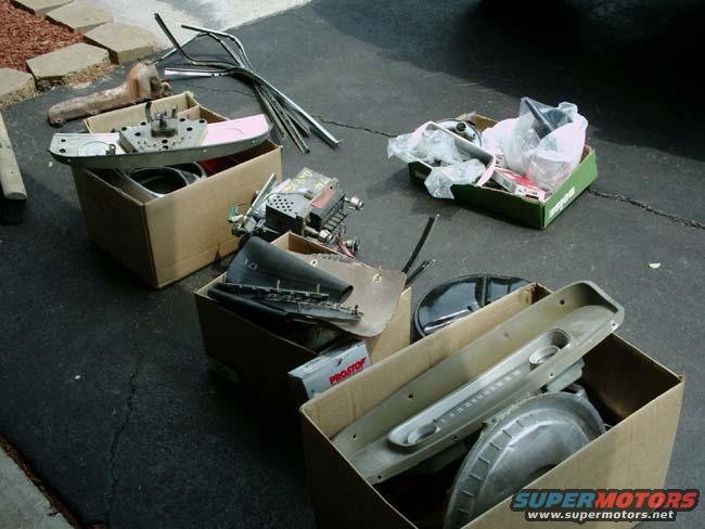 Car parts in cardboard boxes on asphalt