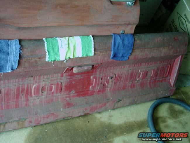 Red 1966 Ford F-250 tailgate with embossed lettering and towels