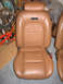 1997 Ford Crown Victoria - A tan leather car seat is shown, with a black emblem on the headrest area.