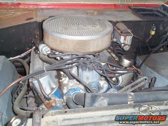 Engine bay of a Ford vehicle, showing the V8 engine, air filter, and brake fluid reservoir