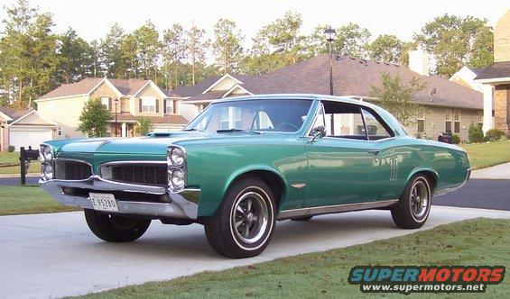 Green 1967 Pontiac GTO parked in driveway, front quarter view. License plate E 95280