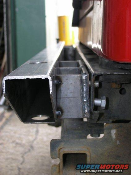 Custom metal bumper bracket with welded supports and bolt mounts, attached to a rusty frame