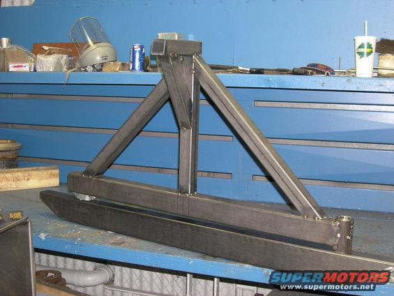 Metal bumper assembly with triangular supports, sitting on a workbench