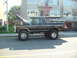 1979 Ford Bronco - This lifted 1979 Ford Bronco is parked on the street with its hood open, revealing the engine bay.