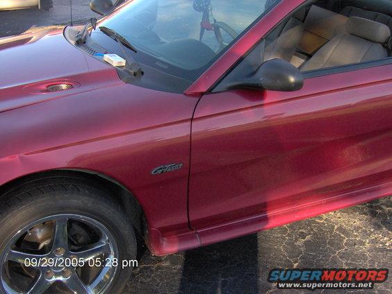 Red 1996 Ford Mustang GT convertible, front quarter view, showing fender, door, and side skirt