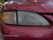 1996 Ford Mustang - Front passenger side headlight and turn signal assembly on a red car.