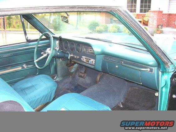 Teal interior of a 1965 Pontiac Tempest, showing dashboard, steering wheel, and seats