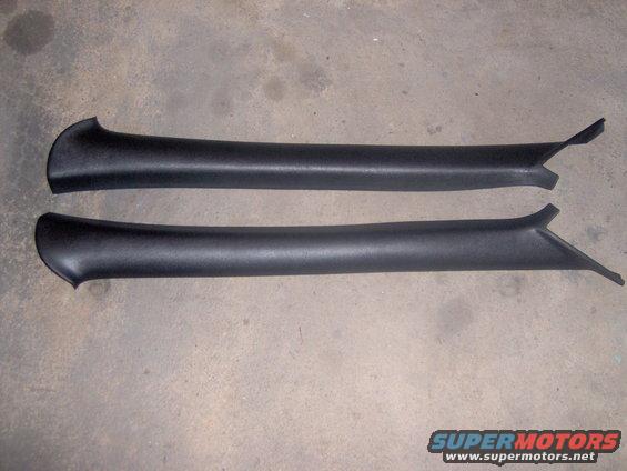 Two black plastic trim pieces on a concrete floor