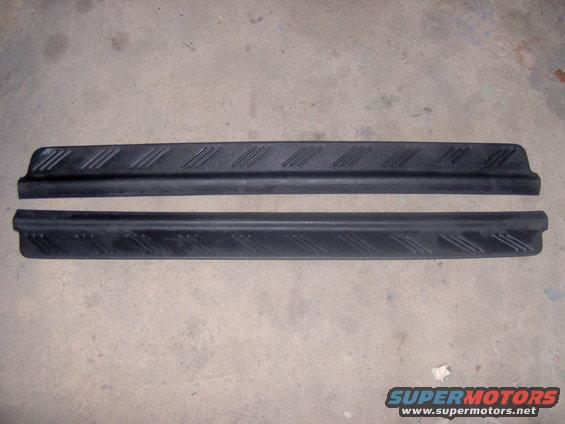 Two black plastic door sill protectors with diagonal tread pattern