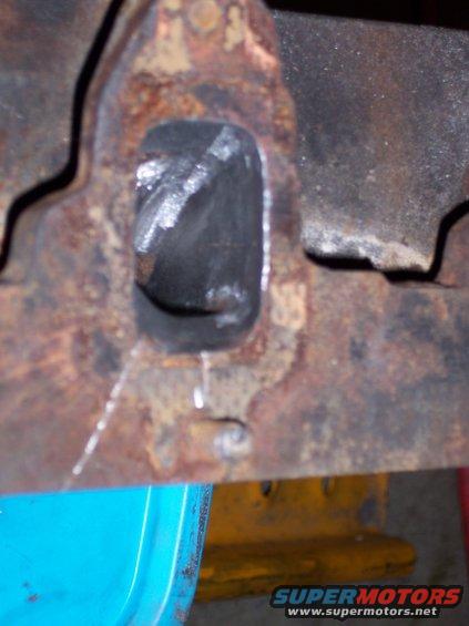 Rusted metal bracket with a rectangular hole, showing wear and tear