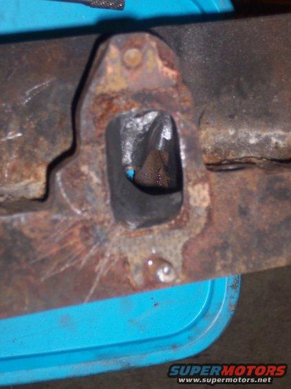 rusted metal exhaust manifold with a rectangular opening