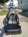 1995 Ford Probe - A black leather car seat is displayed outdoors on a concrete surface.